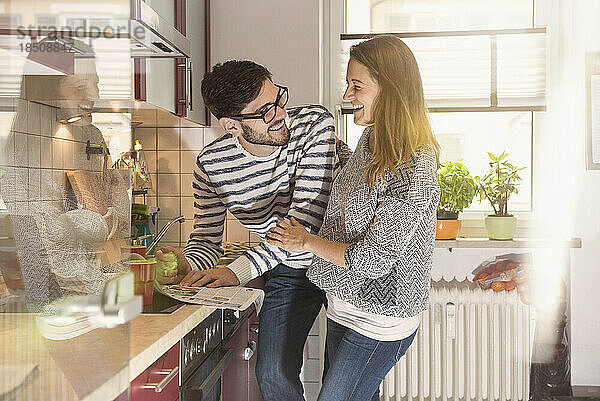 Glückliches Paar liest Zeitung in der Küche  München  Deutschland