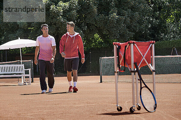 Zwei junge Männer gehen auf dem Tennisplatz  Bayern  Deutschland