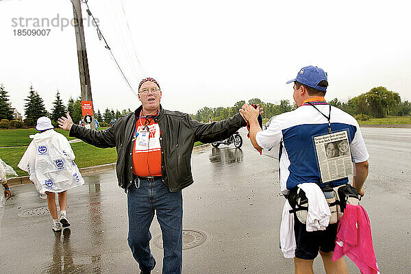 Mann gibt Wanderer zu Beginn eines Brustkrebs-Spaziergangs in Detroit High Fives.
