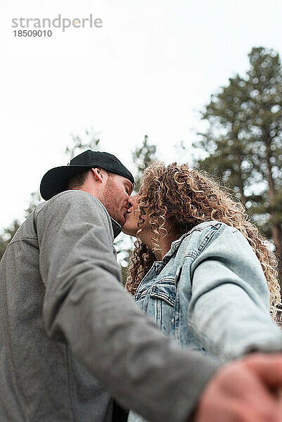 Abenteuerlustiges junges Paar küsst sich im Winter in den Colorado Mountains
