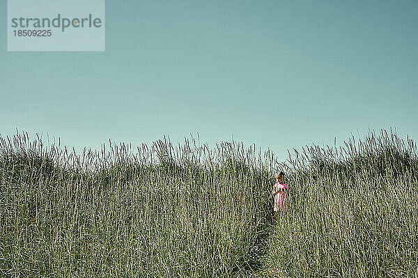 Kleines Mädchen auf einer ruhigen grünen Wiese in Island