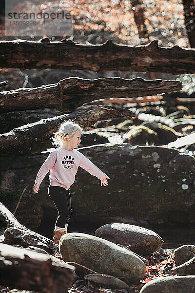 Kleines Kind spielt auf Felsen in der Natur