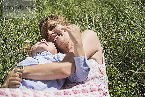 Frau mit ihrem Sohn liegt auf Gras und genießt Picknick  Bayern  Deutschland
