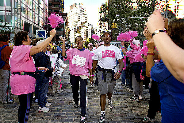 Afroamerikanisches Paar erhält Jubel am Ziel des Avon Walk for Breast Cancer in New York City
