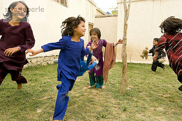 Kinder lachen und spielen im Hof ??ihres Hauses in Kabul.