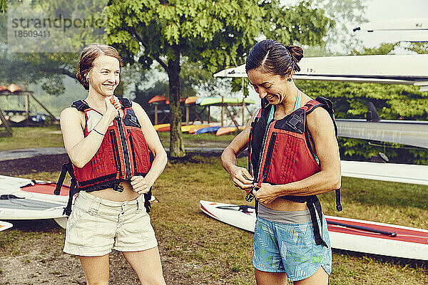 Zwei junge Frauen bereiten sich auf das Standup-Paddle-Boarding vor