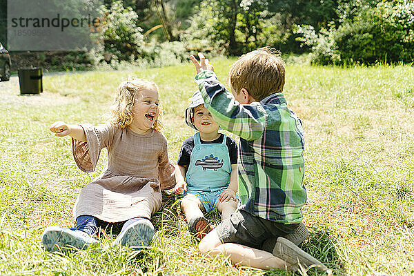 Nahaufnahme von drei kleinen Kindern  die zusammen auf einem Campingausflug spielen