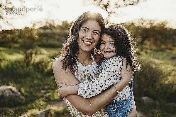 Porträt einer jungen Mutter und Tochter auf einem sonnigen Feld