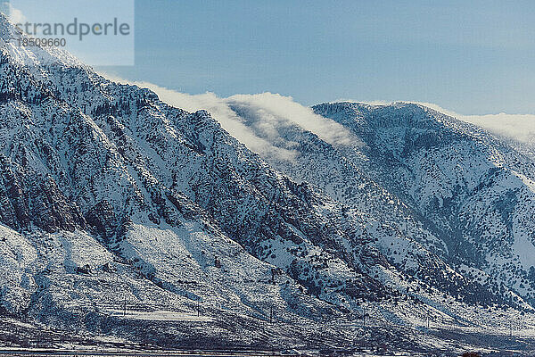 Die schroffen Berge Utahs spiegeln sich im hellen Schnee.