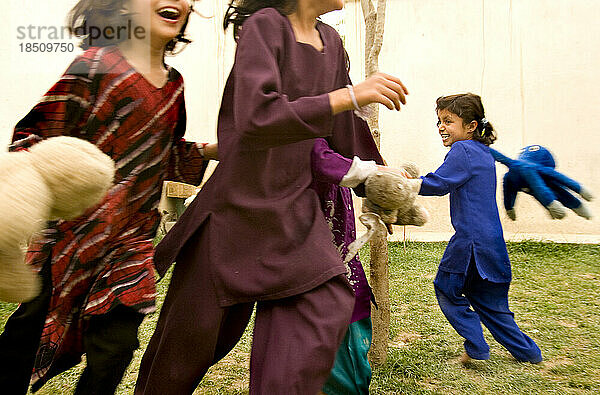 Kinder lachen und spielen in einem Kabuler Innenhof.