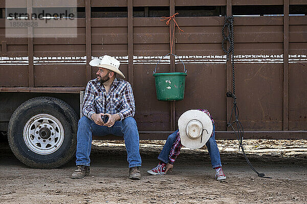 Ein Vater und ein Sohn ruhen sich aus  bevor das Arizona Black Rodeo beginnt