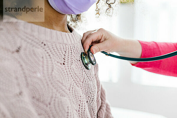 Das Stethoskop wird direkt über dem Herzschlag eines gemischtrassigen Kindes platziert  um zuzuhören