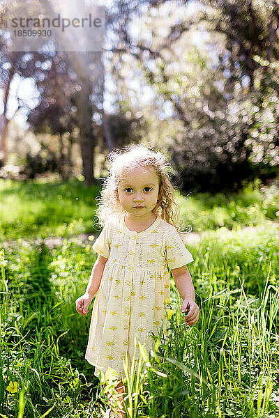 Zweijähriges Mädchen steht an einem sonnigen Tag in San Diego im Feld