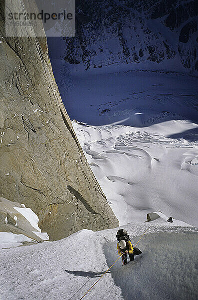 Ein Kletterer klettert während einer Besteigung des Gipfels im argentinischen Pat. an einem Seil an der Ostwand des Cerro Torre hinauf  darunter der Torre-Gletscher