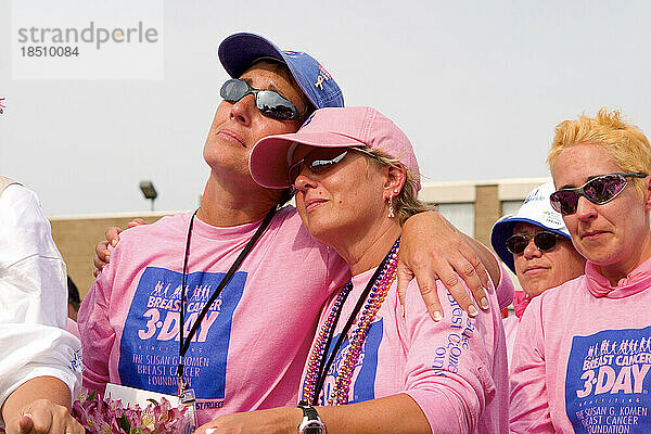 Brustkrebsüberlebende in rosa Hemden umarmen sich während der Abschlusszeremonie des Komen 3-Tages-Spaziergangs gegen Brustkrebs in Detroit
