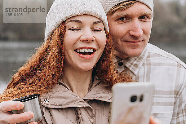 30-35 verliebtes Paar macht Selfie oder Videoanruf beim Gehen