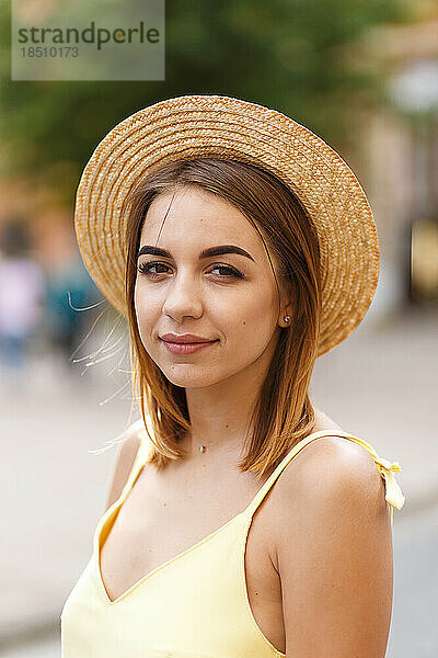 Junges touristisches Mädchen in einem gelben Kleid und einem Hut im Sommer