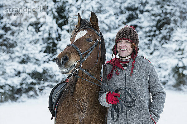 Reife Frau mit Pferd im Winter  Bayern  Deutschland