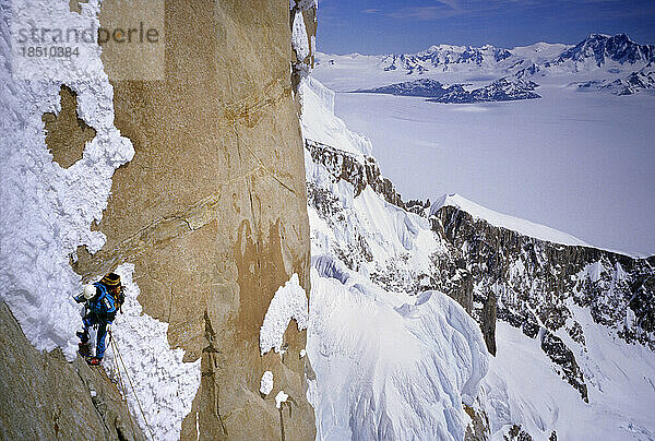 Ein Bergsteiger erklimmt die Nordwestwand des Cerro Torre im argentinischen Patagonien  mit der südlichen kontinentalen Eiskappe im Hintergrund