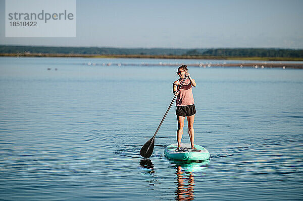 Frau auf Stand-Up-Paddleboard auf dem Meer im Sommer