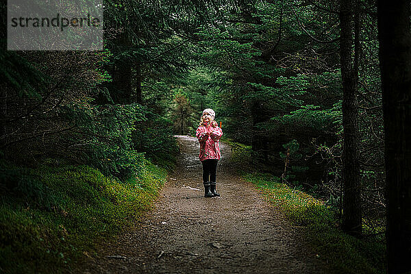 Kleines Mädchen auf geheimnisvollem Waldweg
