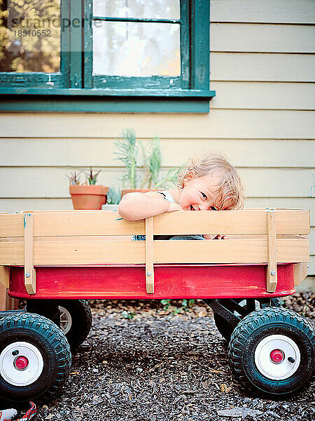 Toddler smiles in radio flyer red wagon  Marin  California.