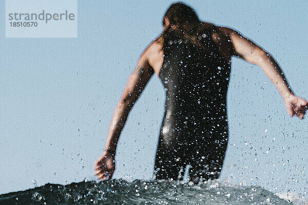 Verschwommener männlicher Surfer von hinten gesehen