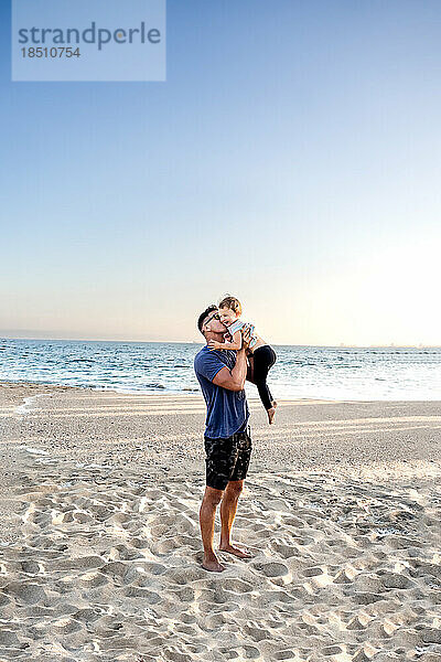 Papa küsst Tochter am Strand