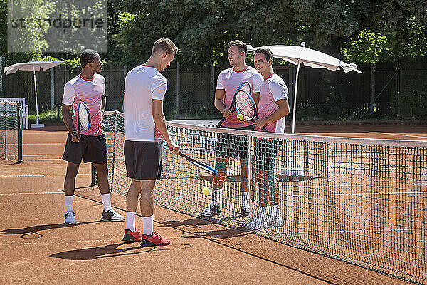 Gruppe junger Männer spielt Tennis an einem sonnigen Tag  Bayern  Deutschland