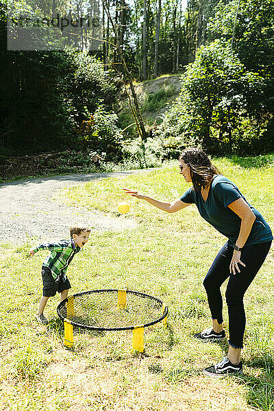 Seitenansicht einer Frau und eines Kindes  die beim Camping ein Spiel spielen