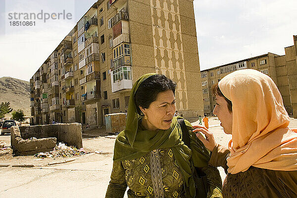 Zwei Frauen gehen aus Wohnblöcken in Kabul.