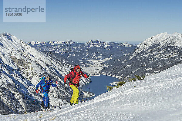 Skifahrer klettern auf schneebedeckten Berg