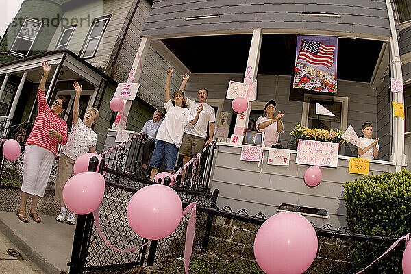 Family members of a breast cancer victim decorate their house to support a breast cancer walk.