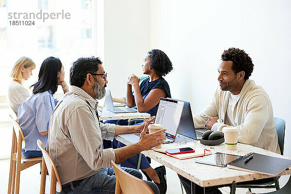 Männliche Unternehmer diskutieren während eines Treffens im Café