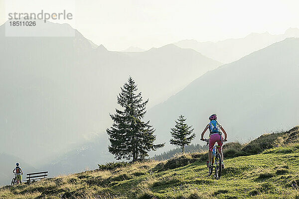 Mountainbiker fahren bergauf in alpiner Landschaft  Zillertal  Tirol  Österreich
