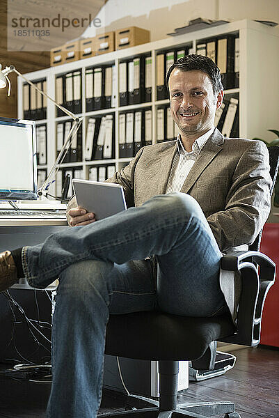 Porträt eines reifen Geschäftsmannes mit digitalem Tablet in einem Büro  Bayern  Deutschland