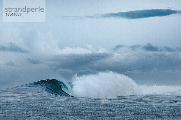 Welle bricht an einem Strand auf den Mentawai-Inseln