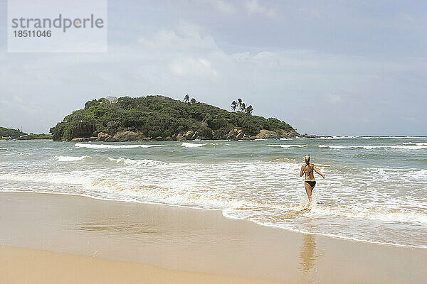Rückansicht einer Frau  die am Strand spaziert  Westprovinz  Sri Lanka