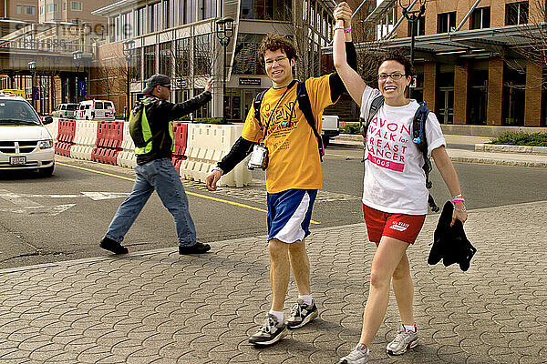 Beim Avon Walk for Breast Cancer in Boston heben Läufer ihre Arme zum Sieg.