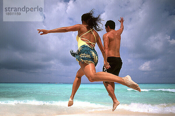 Zusammenfassung eines lustigen Paares  das in Cancun am Strand Mexiko läuft und springt