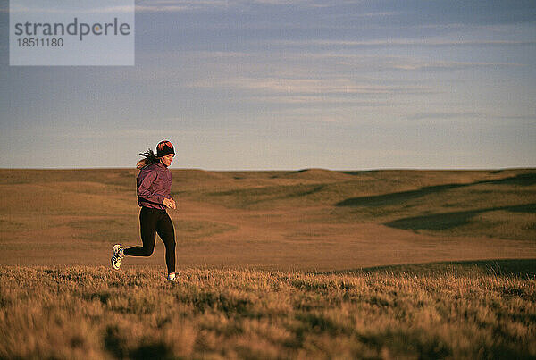 Eine Sportlerin läuft auf einem Hügel.