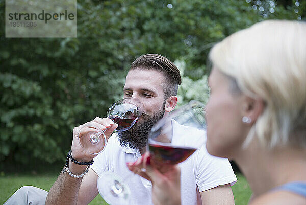 Junges Paar genießt Rotwein beim Picknick  Bayern  Deutschland