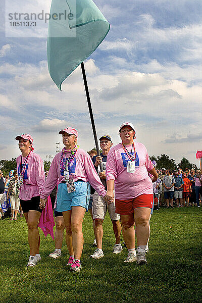 Spaziergänger tragen eine Flagge bei den Abschlusszeremonien des dreitägigen Komen-Spaziergangs gegen Brustkrebs in Detroit  Michigan.