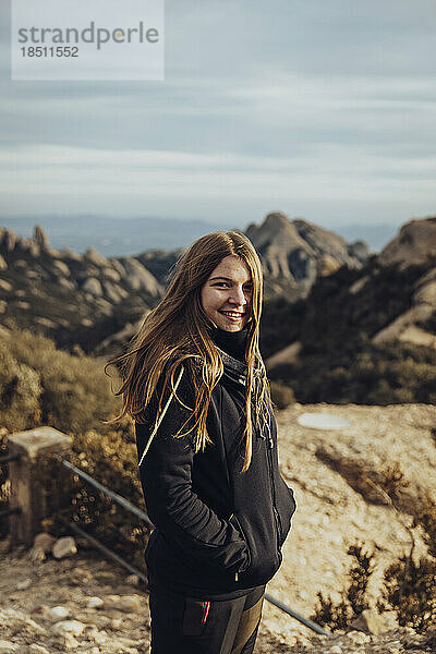 Porträt eines Mädchens in Jacke und Sturmhaube auf einem Berggipfel