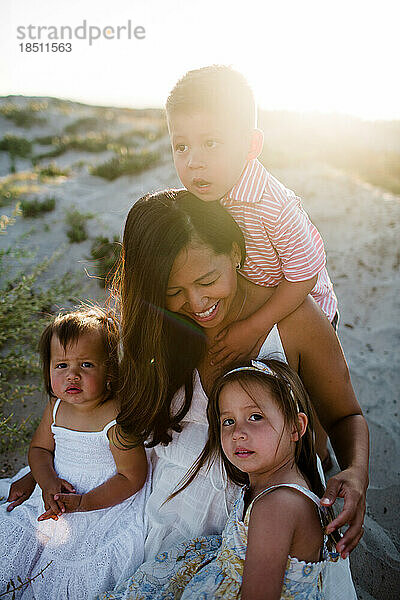 Ehrliches Foto einer Mutter mit ihren drei Kindern am Strand in San Diego