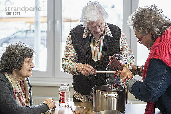 Ältere Frauen bereiten im Pflegeheim Nachtisch zu