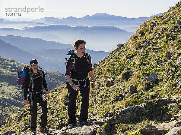 Zwei Frauen gehen während einer Wanderung zum Gipfel des Txindoki