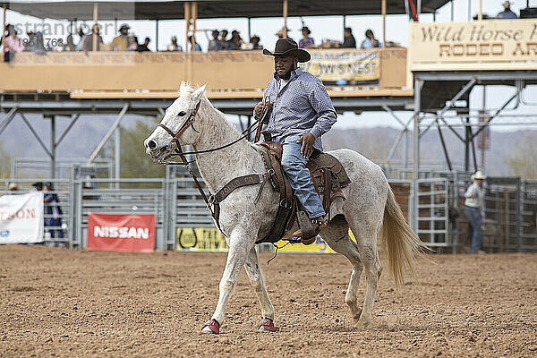 Ein Cowboy betritt zu Pferd den Ring beim Arizona Black Rodeo