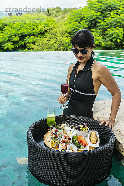 Schöne Frau genießt ein schwimmendes Frühstück in Thailand