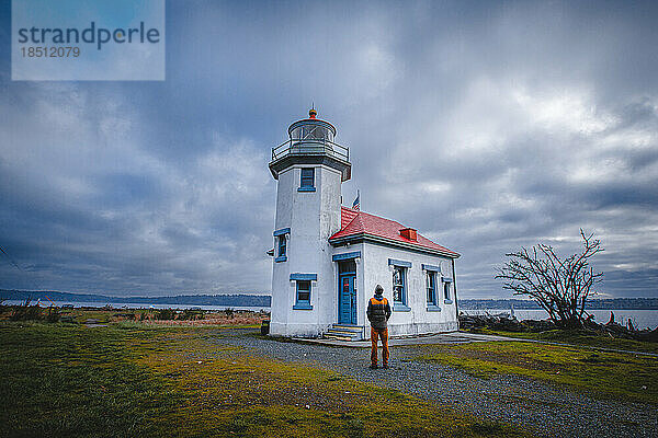 Ein Mann steht in der Nähe eines historischen Leuchtturms auf der Insel Vashon
